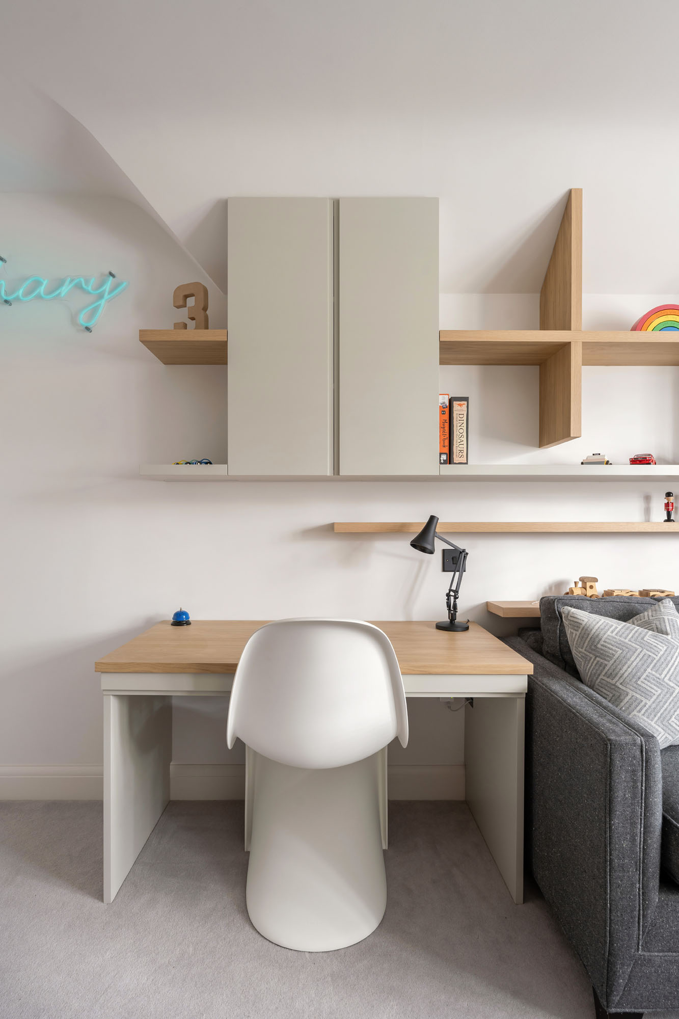 Funky Little Darlings Amersham boys’ bedroom with oak desk, white Panton chair, Anglepoise lamp, built-in storage cupboards, and open oak display shelves.