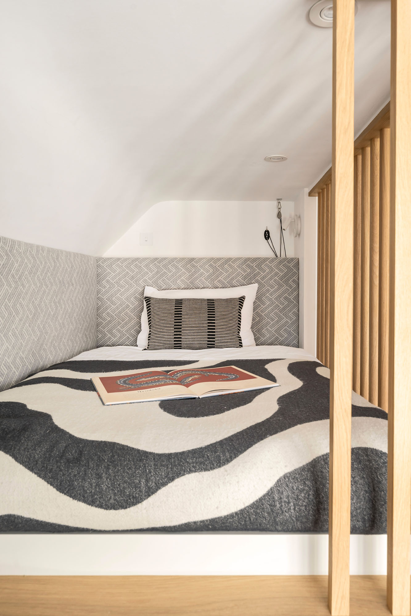 Funky Little Darlings Amersham boy's bedroom featuring a custom loft bed with oak safety bars and upholstered headboard in a modern elevated sleeping area.