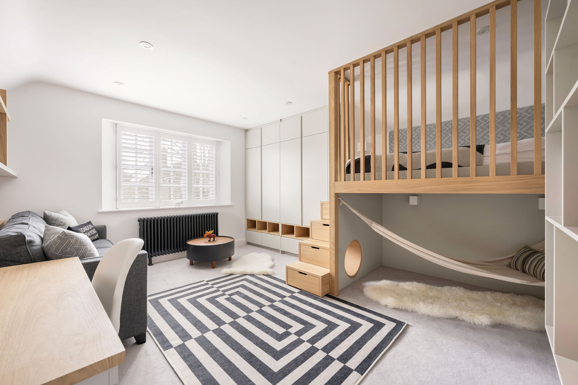 Funky Little Darlings boys' bedroom in Amersham featuring a custom loft bed with storage steps, tunnel play area, and a cozy reading nook with hammock.