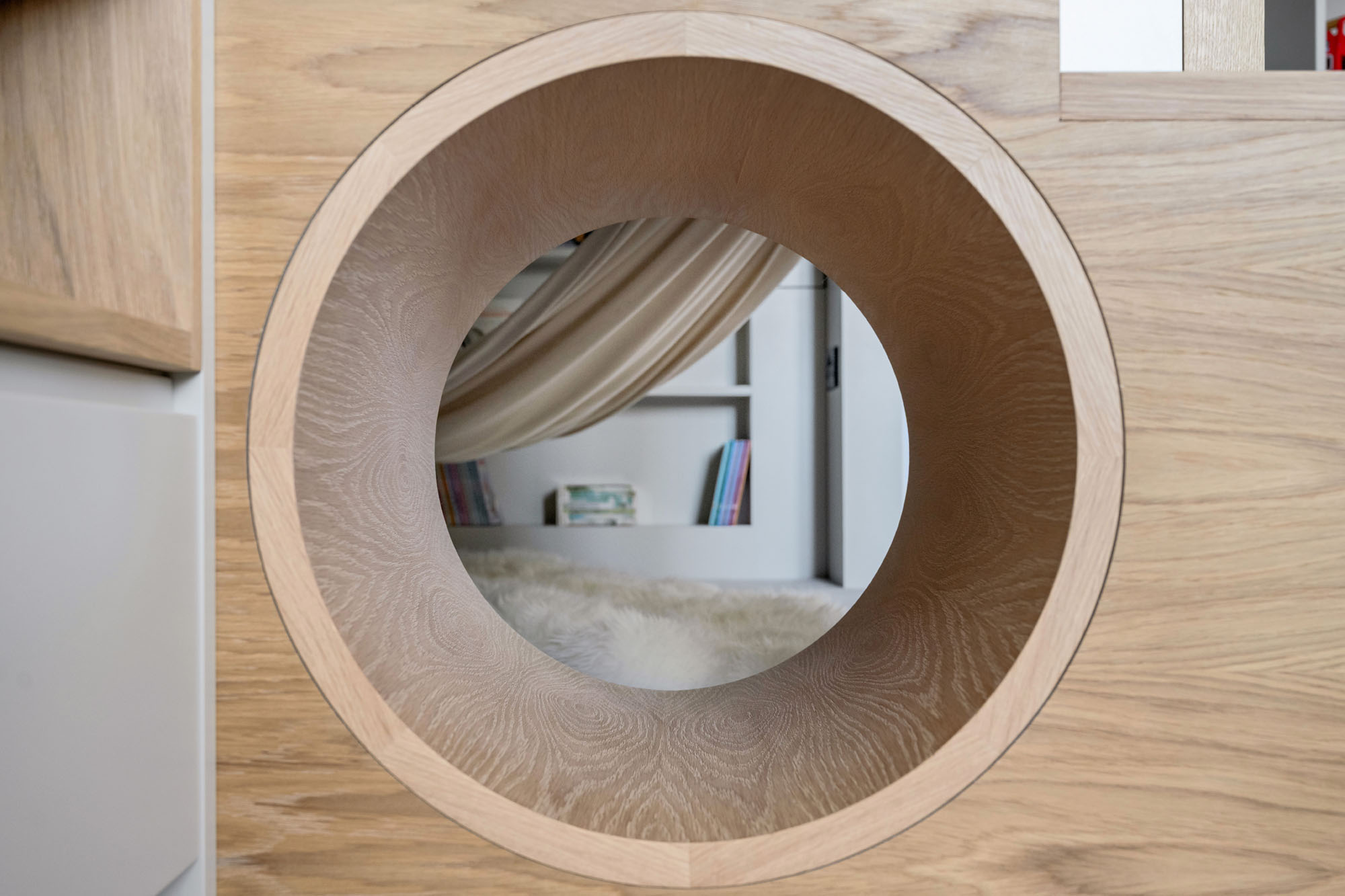 Custom boys bedroom by Funky Little Darlings in Amersham featuring a loft bed, built-in storage steps, a playful tunnel, and a cozy reading nook with a hammock.