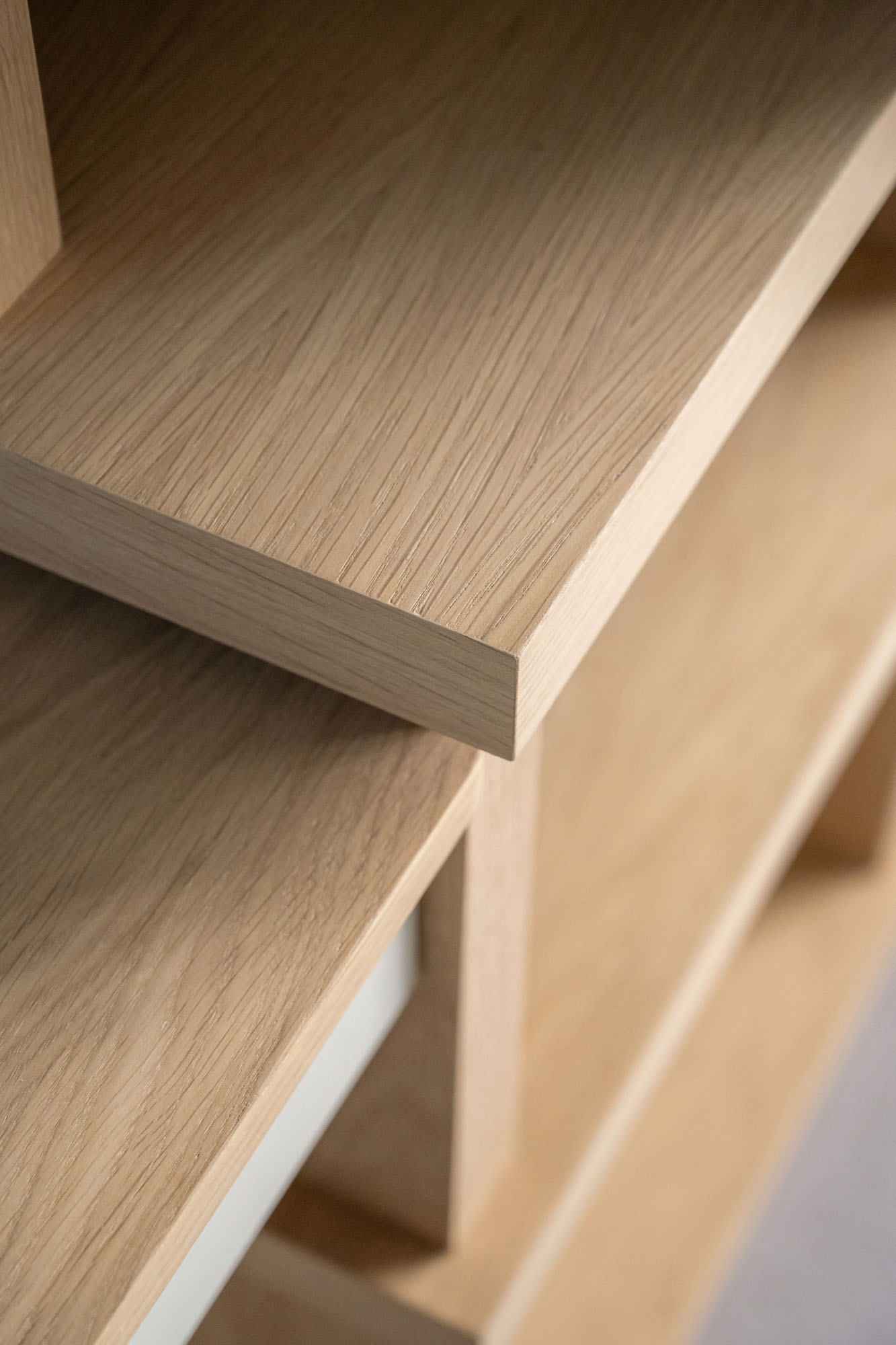 Detail of custom-built oak display shelves with open storage in a boy’s bedroom by Funky Little Darlings in Amersham, bespoke joinery with natural wood accents and playful interior styling.