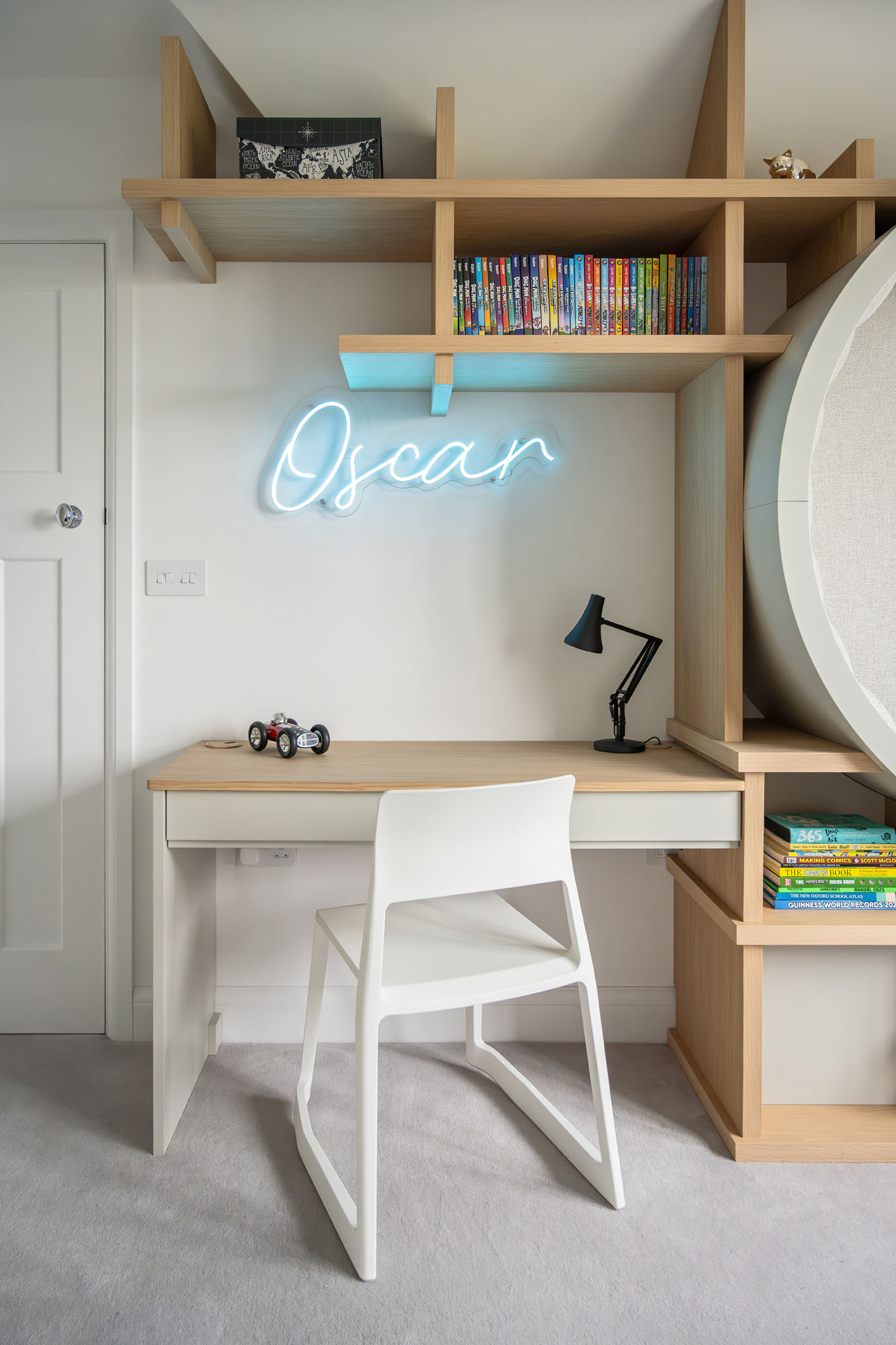 Stylish and functional boy's bedroom workspace in Amersham designed by Funky Little Darlings, featuring a modern Vitra desk chair, personalised neon name sign and open wall-mounted storage, the perfect blend of design, comfort and organisation for a creative child’s room.