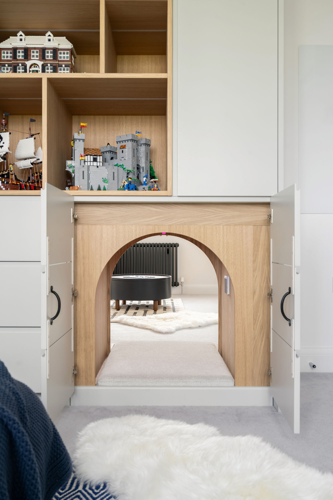 Stylish boys' bedroom in Amersham designed by Funky Little Darlings, featuring bespoke cabinetry, built-in wardrobes, and a secret tunnel connecting to sibling’s room, blending playful design with functional space-saving solutions.