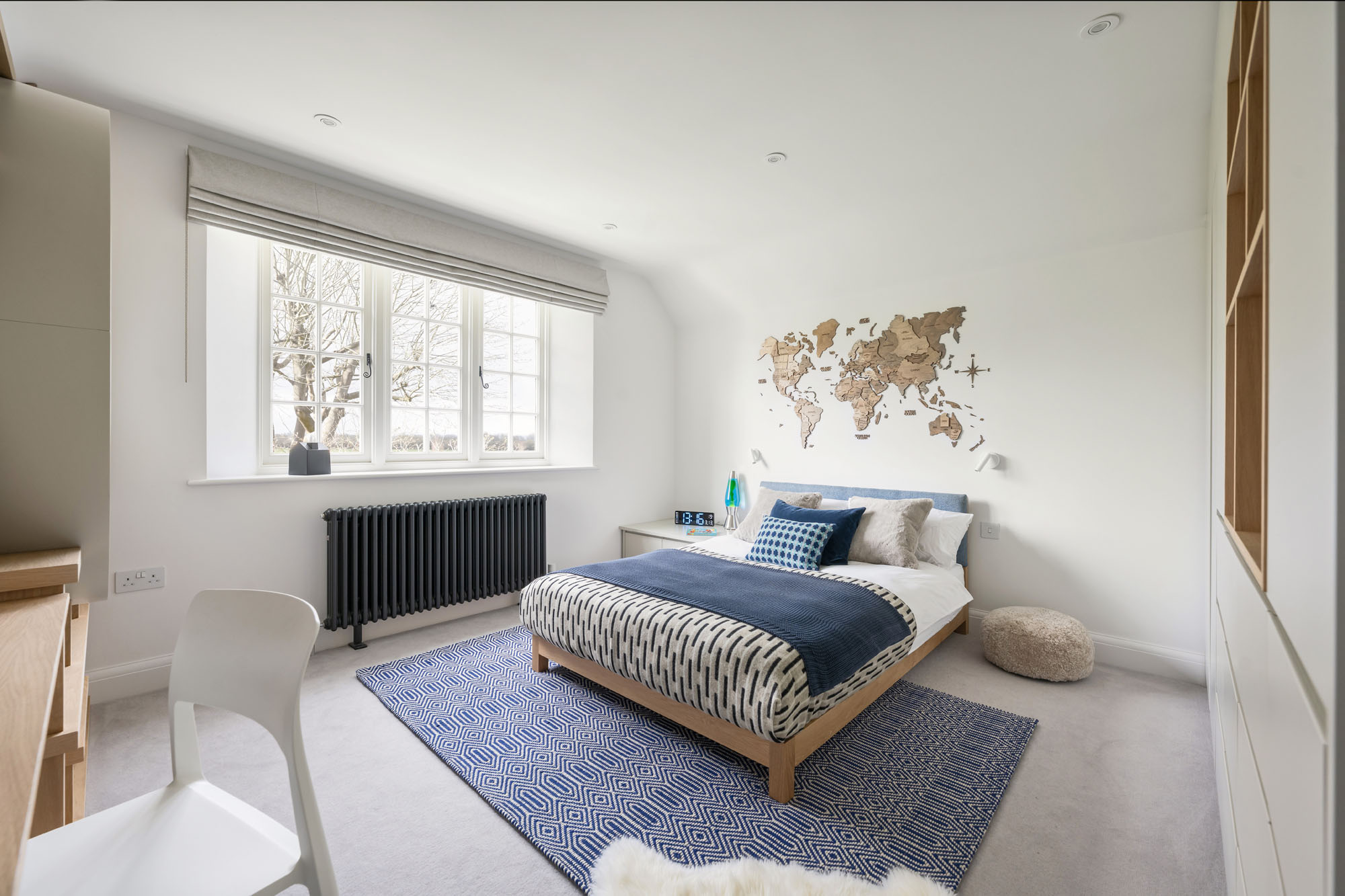 Stylish boy’s bedroom in Amersham featuring bespoke cabinetry, built-in wardrobes, and a decorative world map, designed by Funky Little Darlings to blend functionality with playful, educational design.