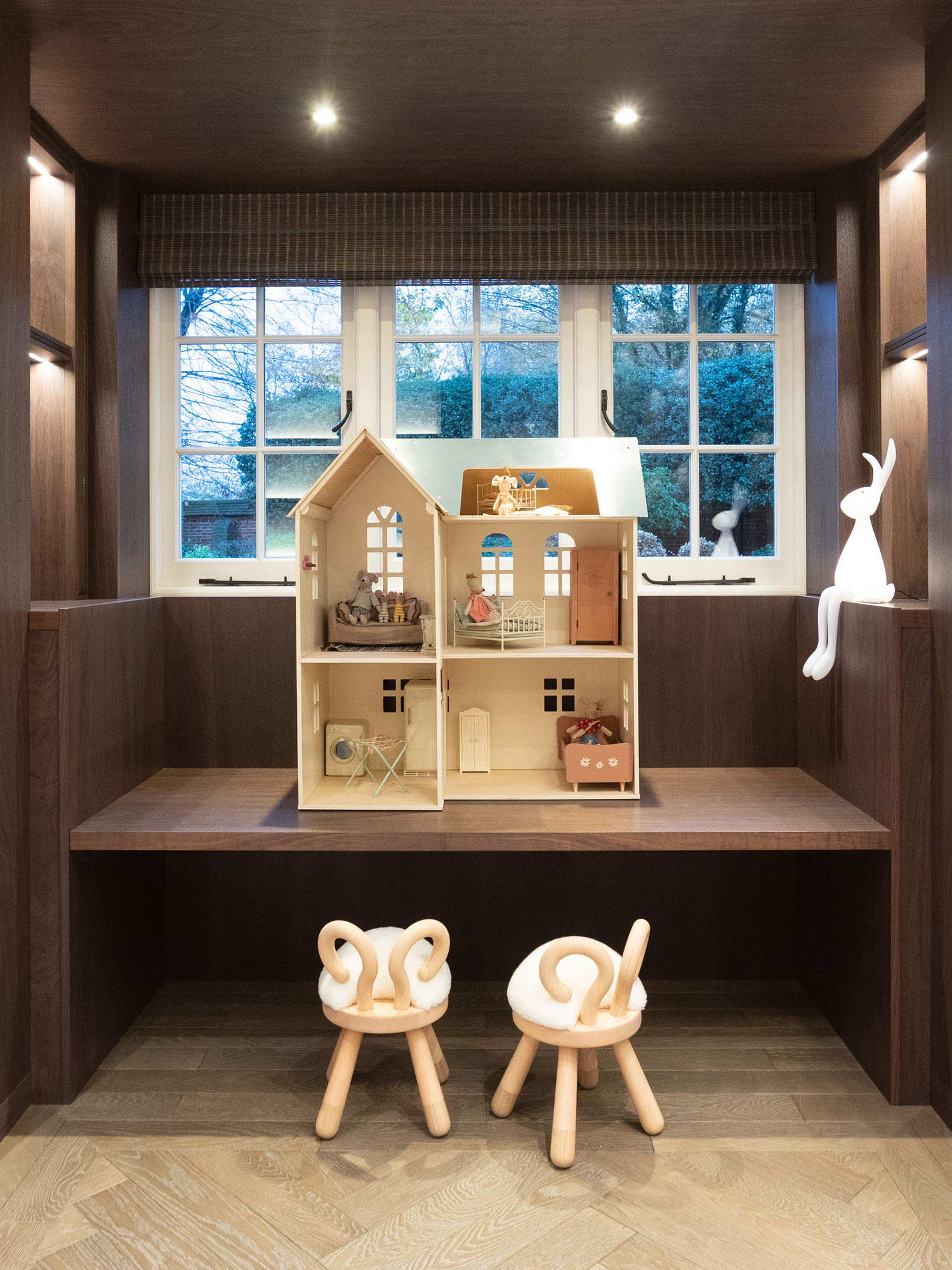 Beautifully designed children’s playroom in Cobham, Surrey, by Funky Little Darlings, featuring a charming wall mounted house-shaped chalkboard, a dedicated Maileg dollhouse play area with stylish EO sheep stools combining imaginative play with luxury interior design for a creative family space.
