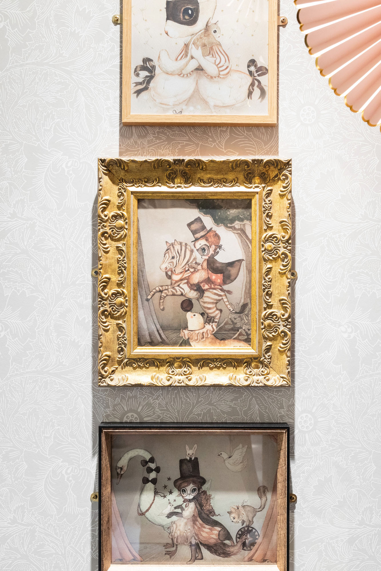 Stylish shared triple children’s bedroom in Cobham by Funky Little Darlings, featuring vintage-framed kids’ artworks, elegant William Morris wallpaper and a blend of classic and playful design elements that create a charming, character-filled space for siblings.