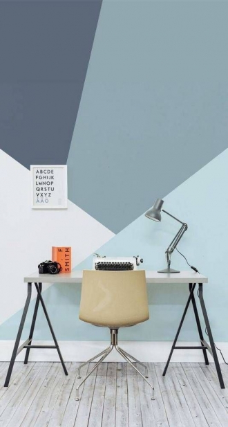 Desk with geometric blue wallpaper in room